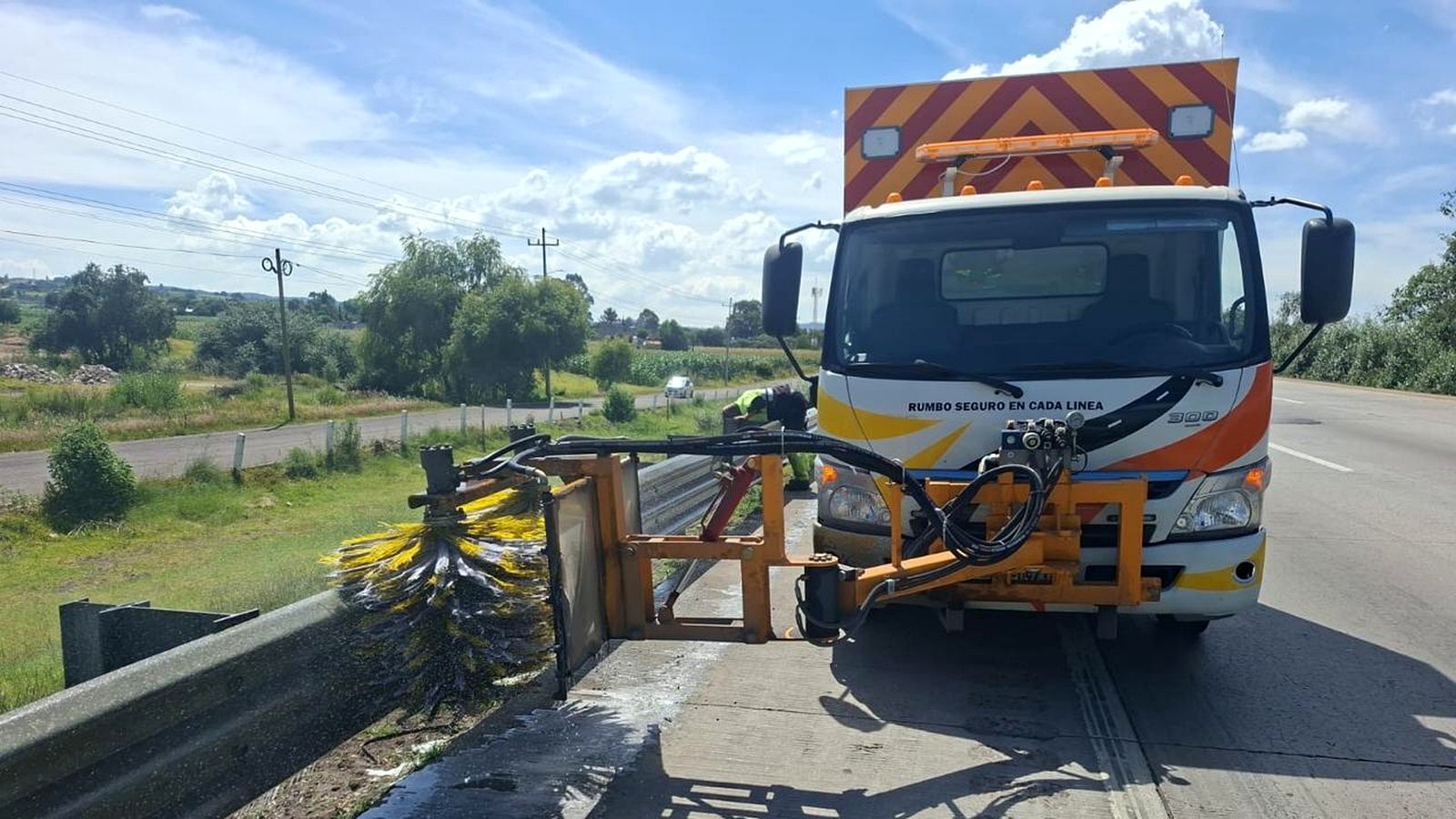 Proceso de lavado de defensa metálica en carretera